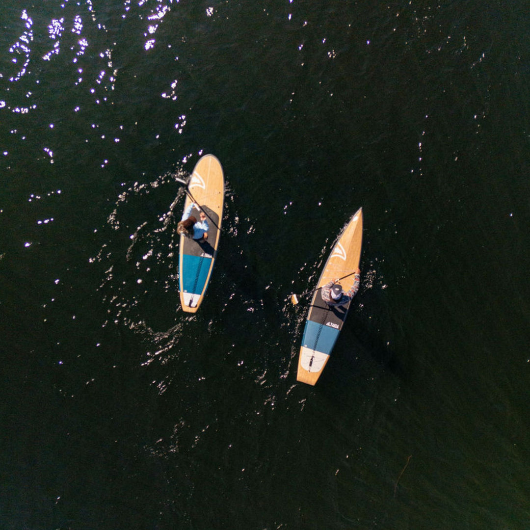 Two paddle boards on a body of water from an aerial perspective