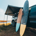 Longboard 9'0" Surf Board Leaning on a Camping VAN