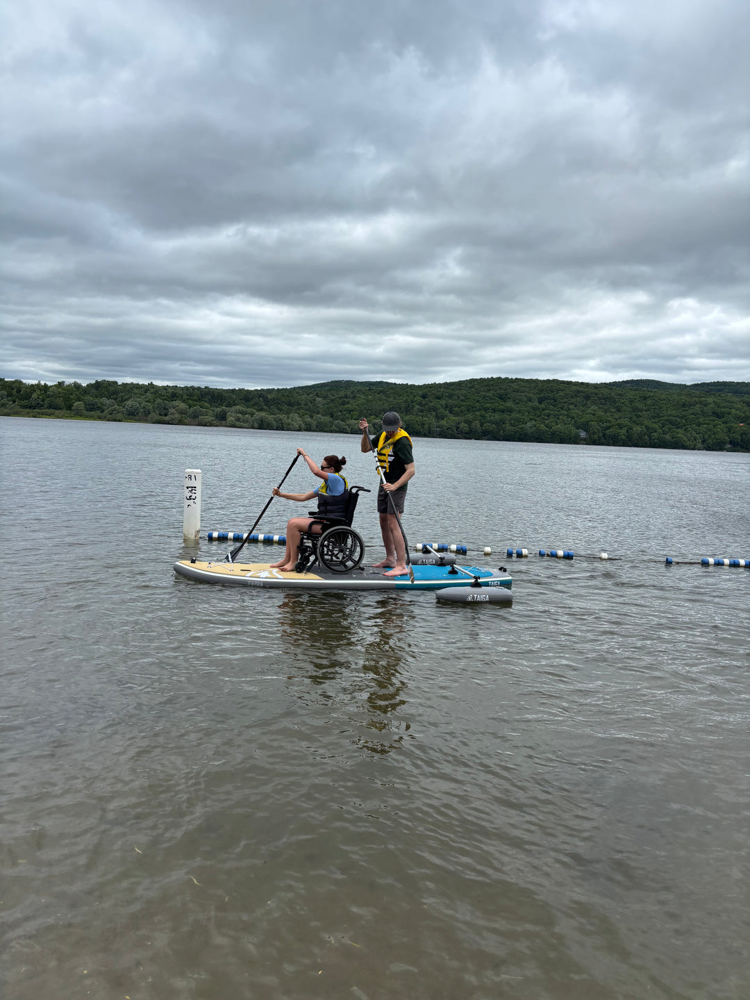 Two paddlers on the TAIGA Adaptive SUP on a lake