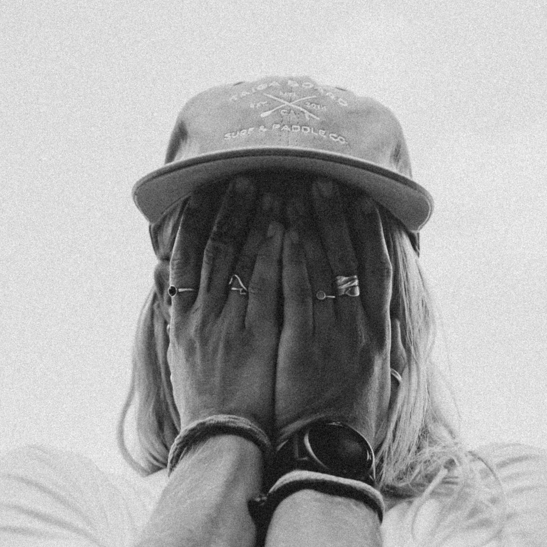 Black and White picture of a girl wearing the Dad Hat Surf & Paddle in Grey