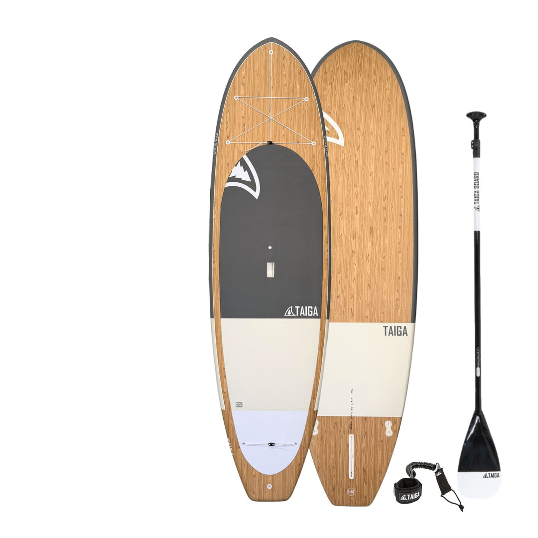 Wooden paddleboard with black paddle and leash on a white background