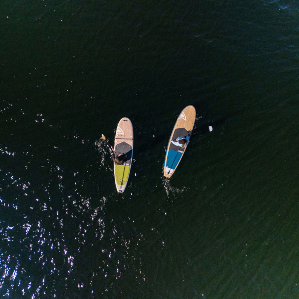 Two paddle boards on a body of water from an aerial perspective