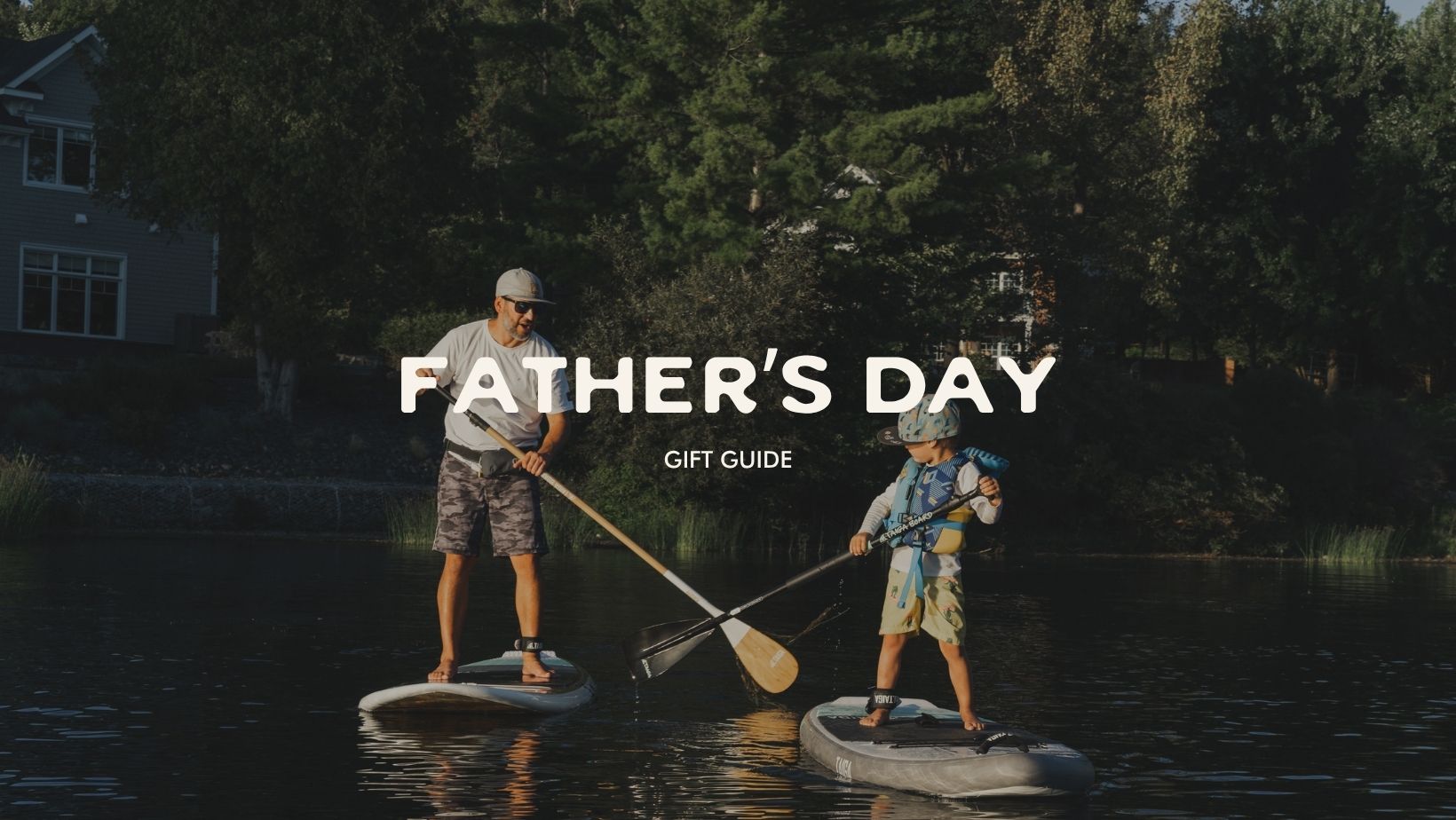 Two people paddleboarding on a lake with 'Father's Day Gift Guide' text overlay.