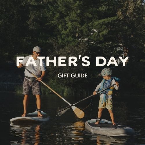 Man and child paddleboarding on a lake with 'Father's Day Gift Guide' text overlay.