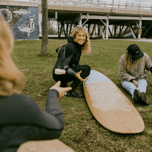 GIF of someone waxing a surfboard
