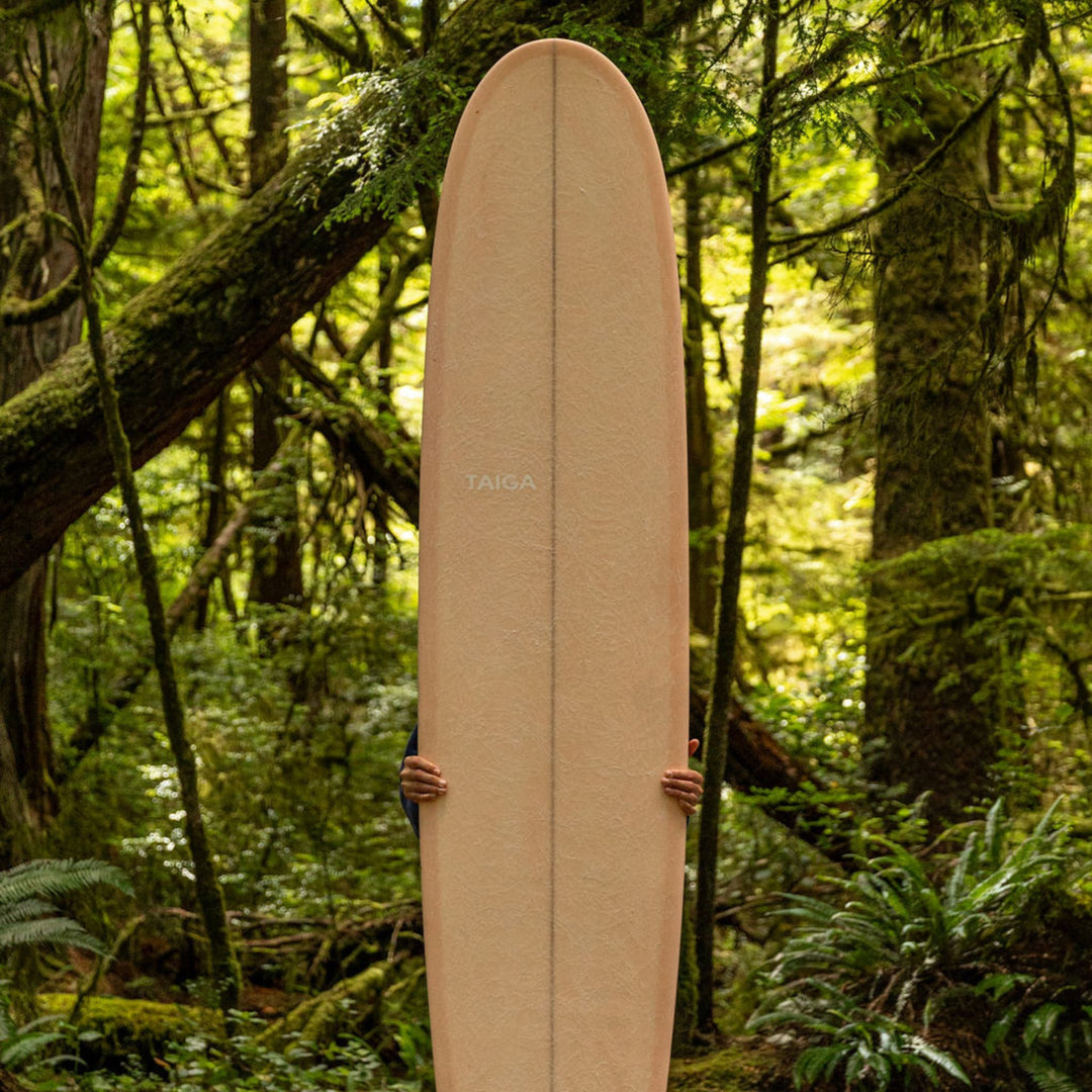 Front View of The Longboard Surf Board in The Rosé Color Being Held