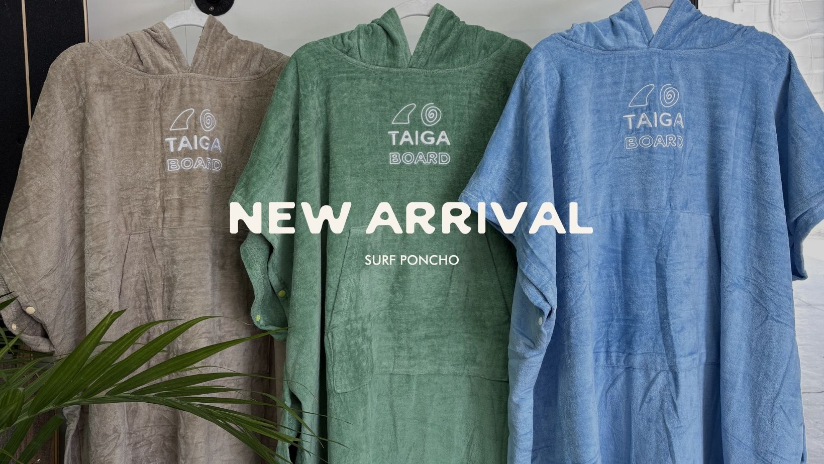 Three hooded ponchos in gray, green, and blue with 'Taiga Board' branding on a white background.