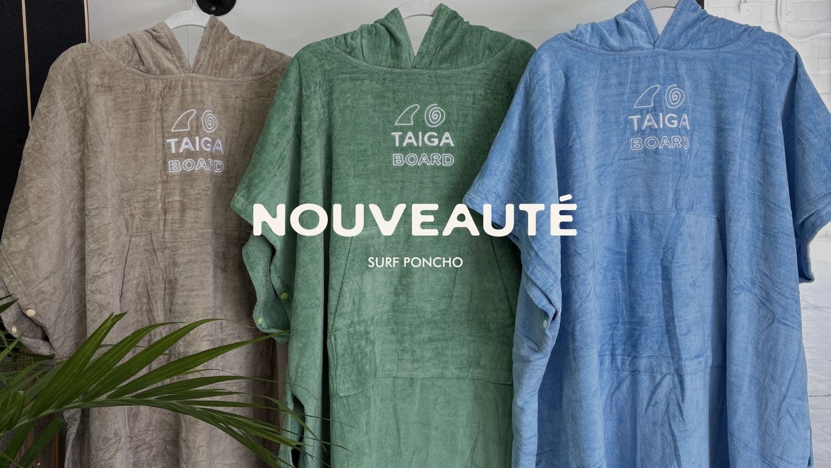 Three hooded ponchos in gray, green, and blue with 'Taiga Board' branding on a white background.