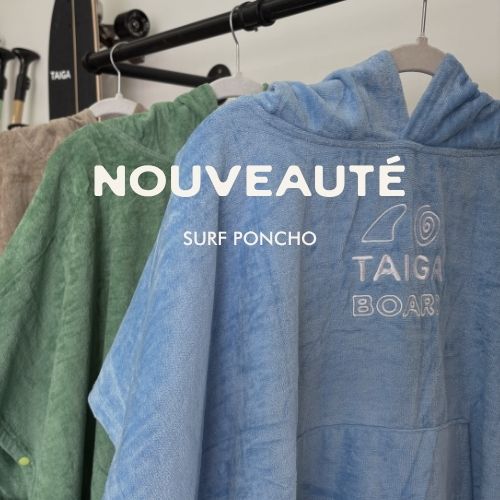 Blue surf poncho with 'Taiga Board' logo on a rack, featuring the word 'Nouveauté'.