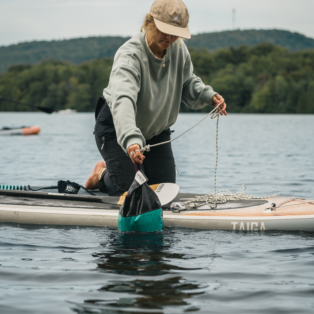 Paddler dropping SUP anchor in water - Turquoise