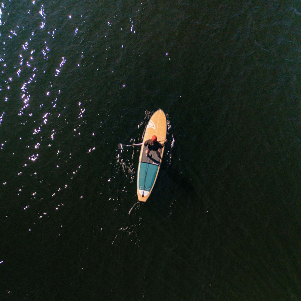 Person paddleboarding on a dark body of water