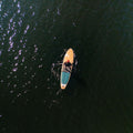 Person paddleboarding on a dark body of water