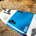 Blue and white inflatable paddle board with 'TAIGA' branding with fins