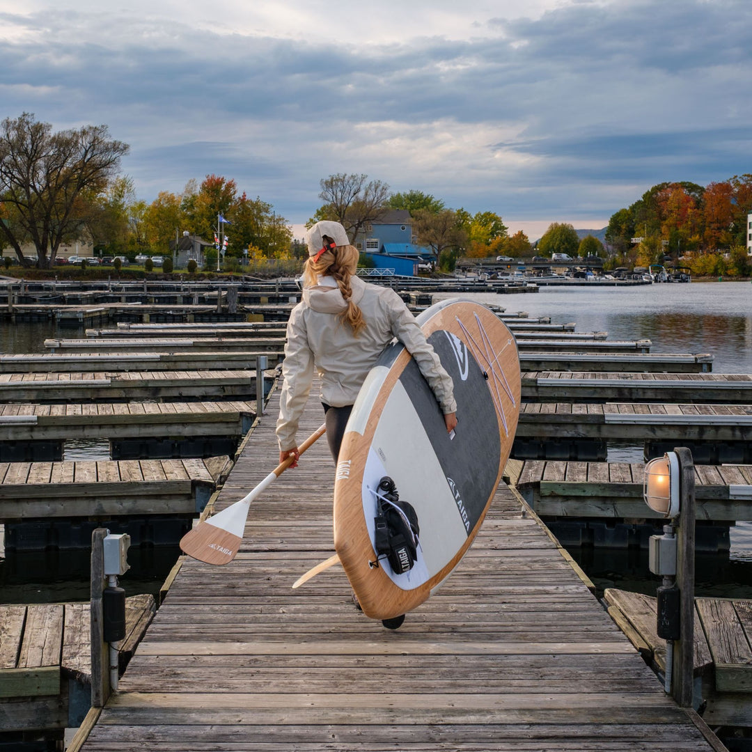 Paddler holding a wooden paddle board