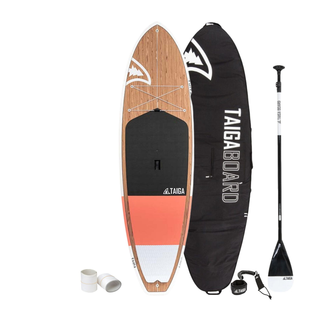 Paddleboard with wooden deck, black and red body, paddle, and carrying bag on a white background