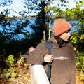 Person using a shoulder strap to carry an inflatable paddle board