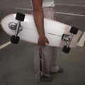 Person holding a pink skateboard in an outdoor setting