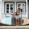 Girl holding the 2-piece Salmon Hybrid Paddle by TAIGA with the Awen Turquoise 10'0 Hard SUP