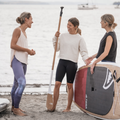 SUP yoga teacher holding the Performance Root Collection Paddle by TAIGA